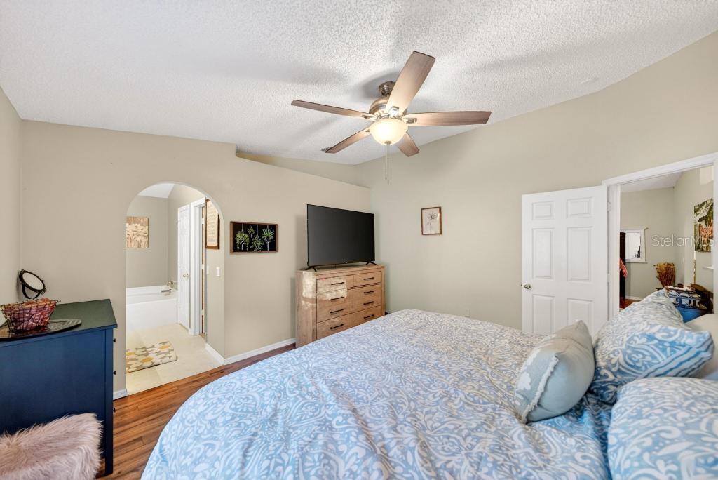 1332 Honey Road Apopka, FL 32712 - Photo 28 of 59 a bedroom with a large bed and a chandelier