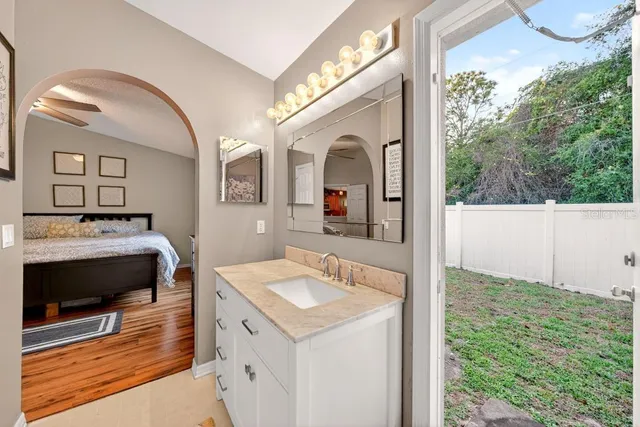 a en suite bathroom with a granite countertop sink and a mirror