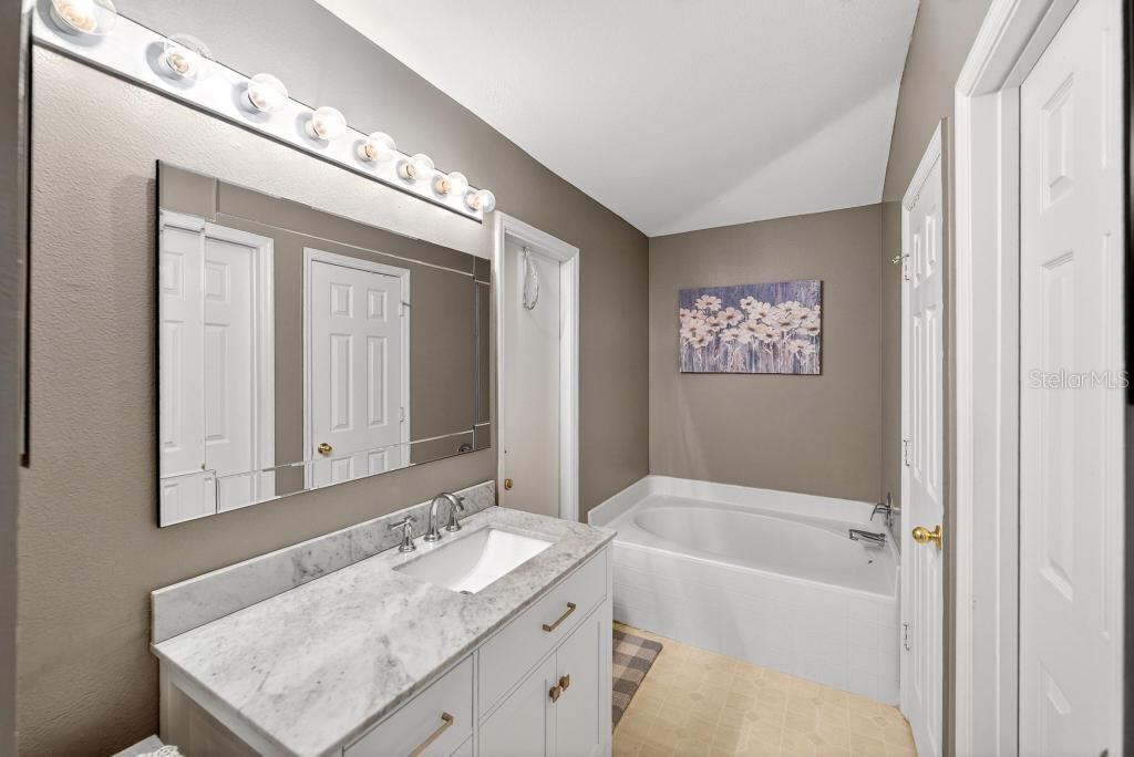 1332 Honey Road Apopka, FL 32712 - Photo 36 of 59 a bathroom with a sink double vanity granite tub and a mirror