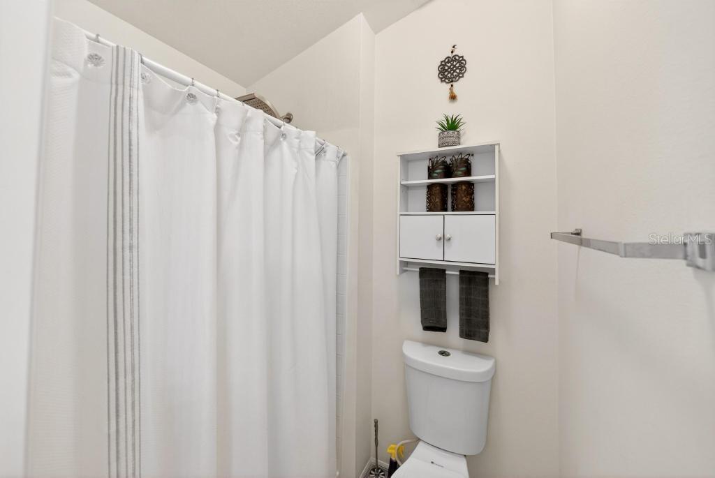 1332 Honey Road Apopka, FL 32712 - Photo 39 of 59 a bathroom with a shower a toilet and a window