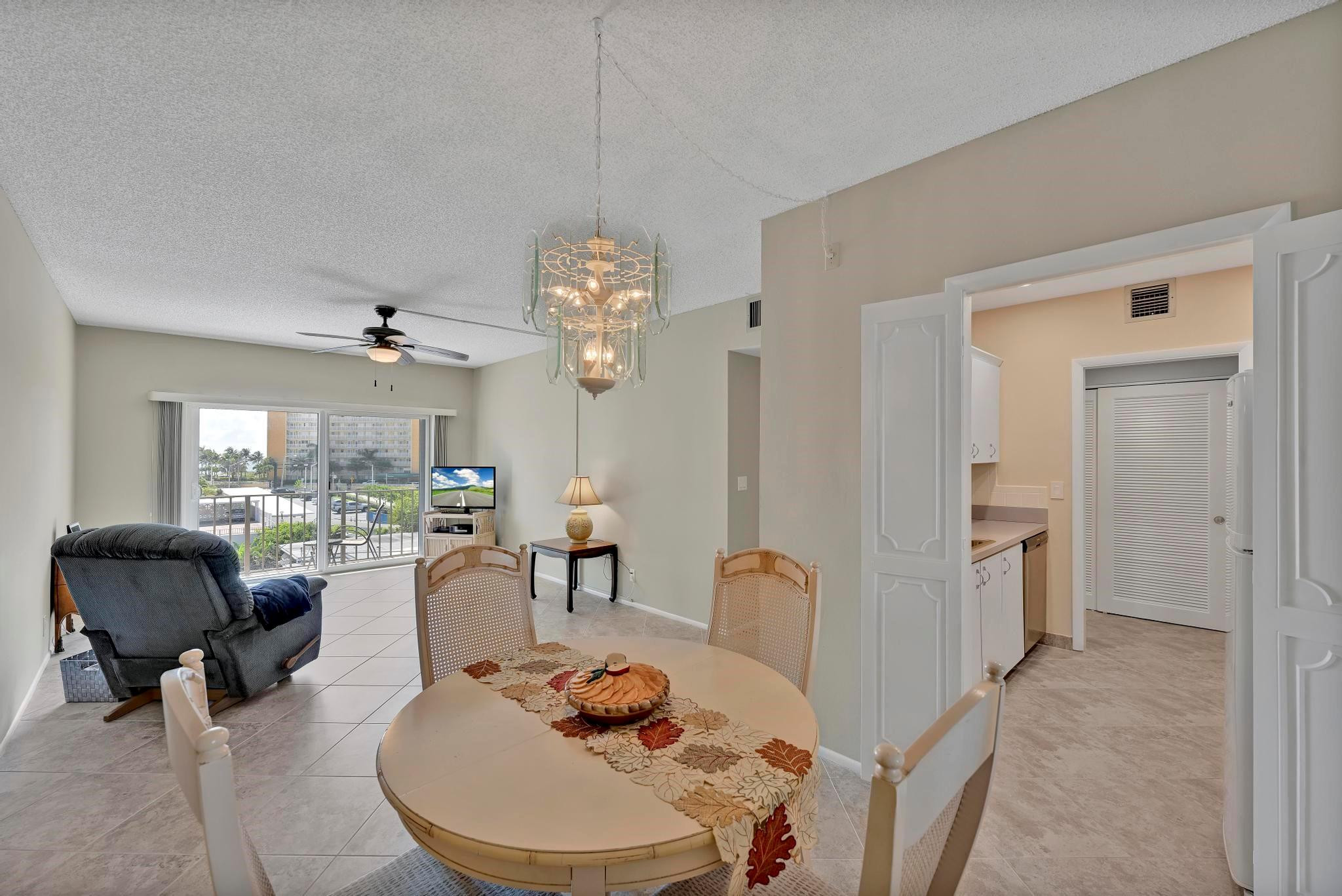 400 North Riverside Drive, Unit 404 Pompano Beach, FL 33062 - Photo 6 of 29 a living room with furniture a chandelier and a dining table