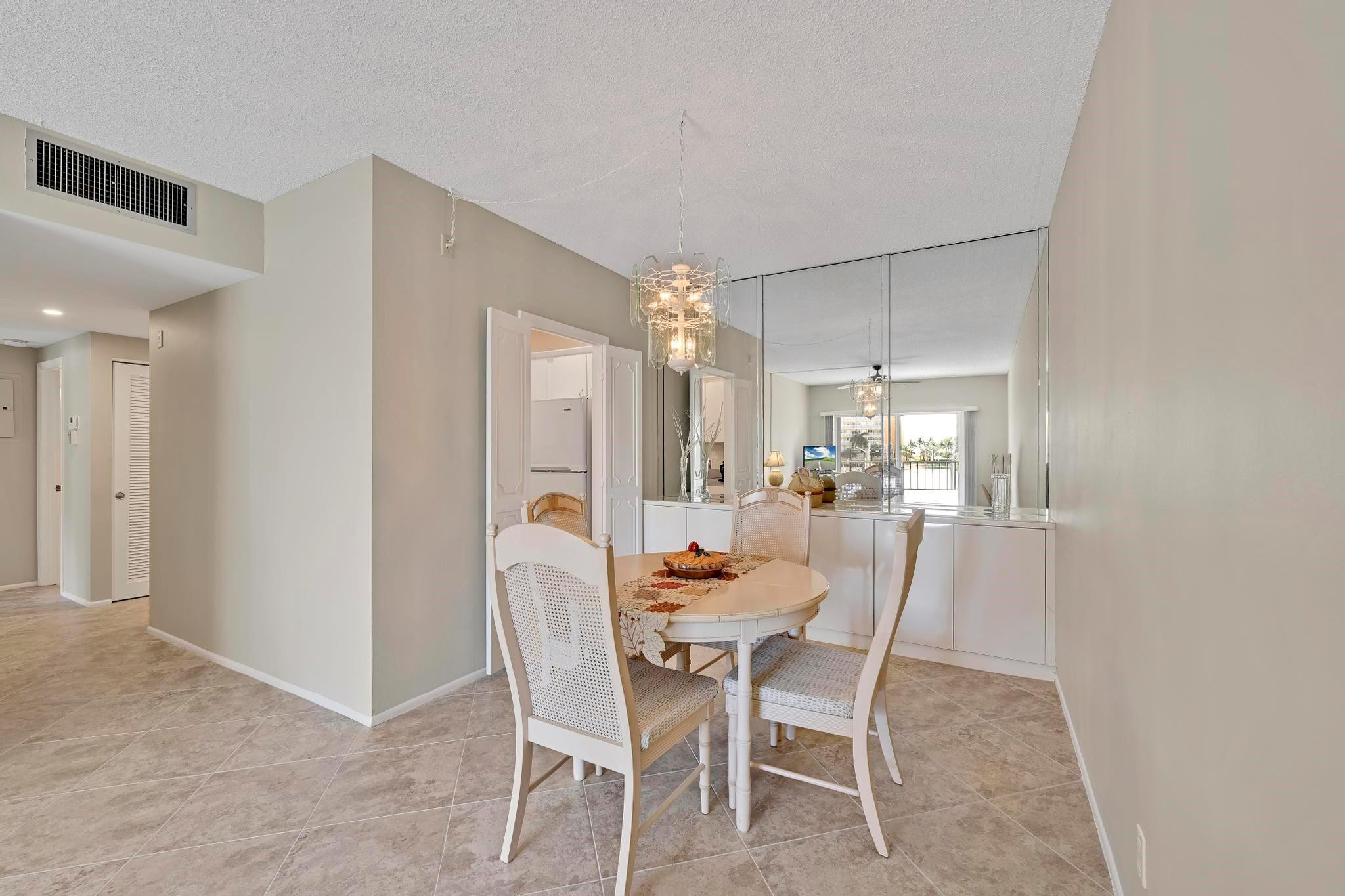 400 North Riverside Drive, Unit 404 Pompano Beach, FL 33062 - Photo 7 of 29 a dining room with furniture and chandelier