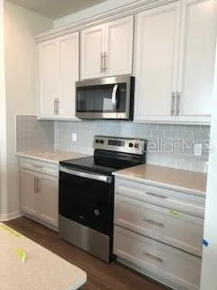 a kitchen with stainless steel appliances granite countertop a stove and a microwave