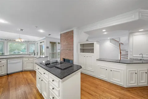 a kitchen with a sink stove and wooden floor