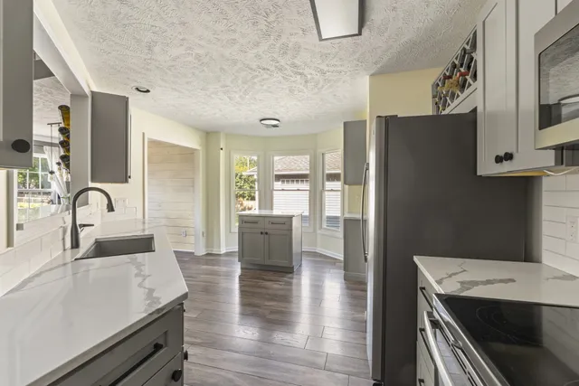 a open kitchen with stainless steel appliances granite countertop a lot of counter space and wooden floors