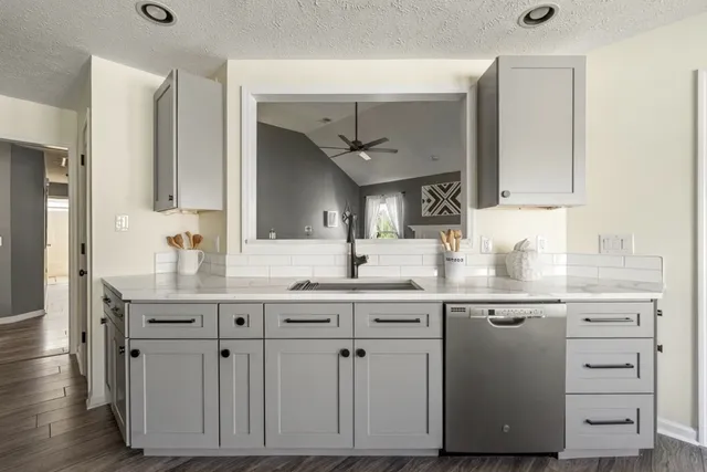 a kitchen with white cabinets and sink
