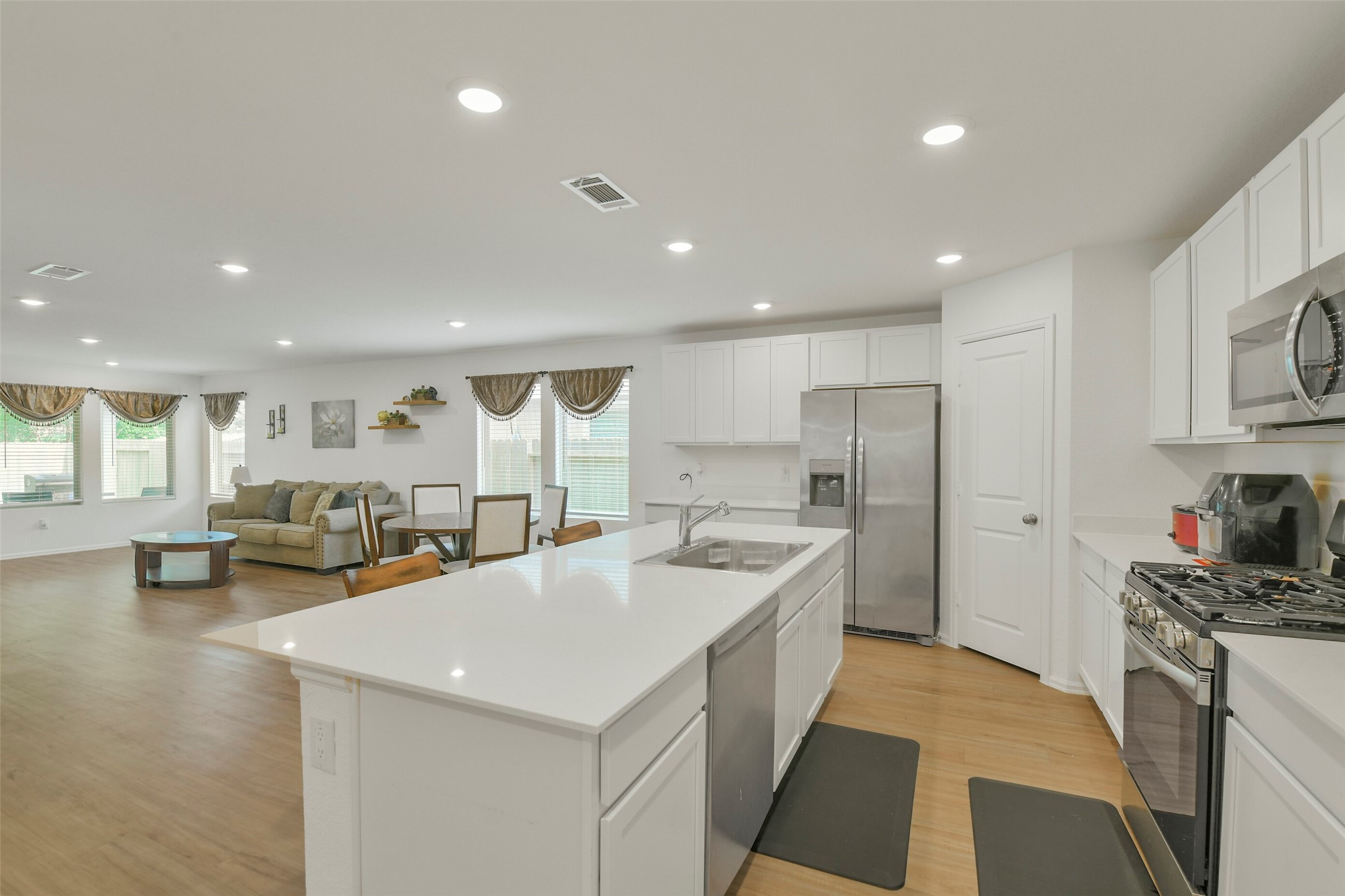 13978 Manatee Street Splendora, TX 77372 - Photo 4 of 39 Modern island kitchen featuring stainless steel appliances, gas cooking, and abundant cabinetry.