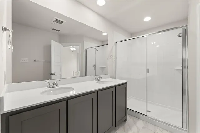 a bathroom with a shower sink vanity and mirror