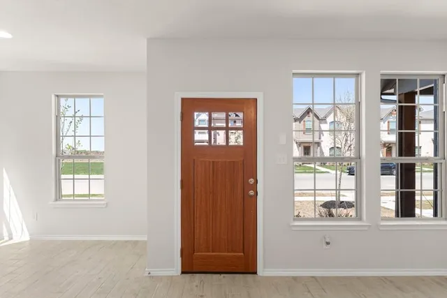 an entryway with wooden floor and windows