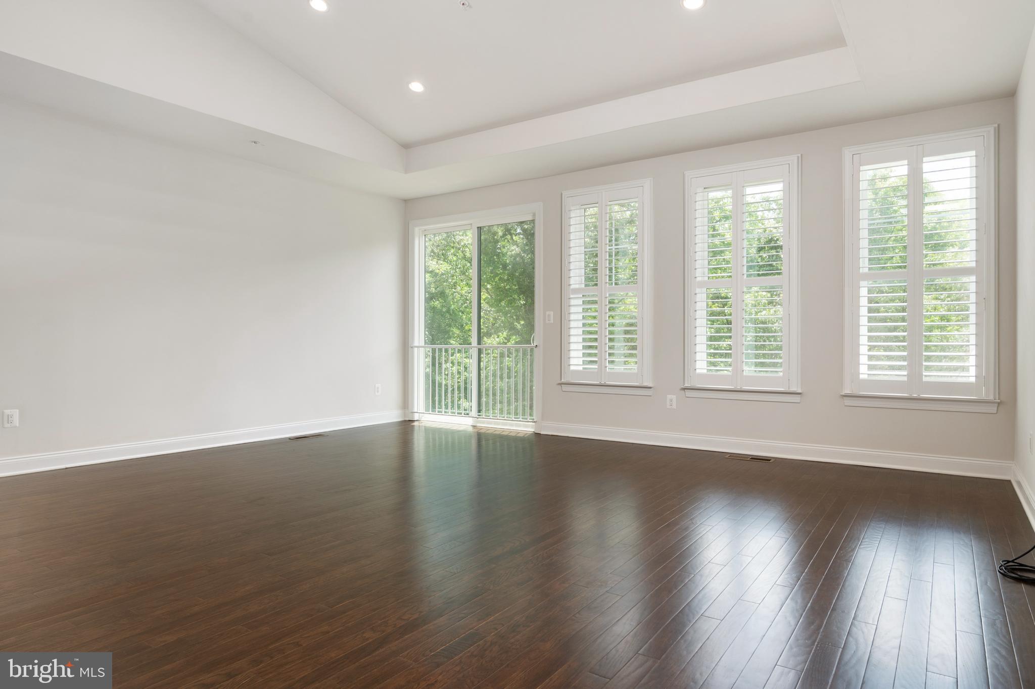 8631 St Anthony Drive Severn, MD 21144 - Photo 11 of 41 a view of an empty room with wooden floor and a window