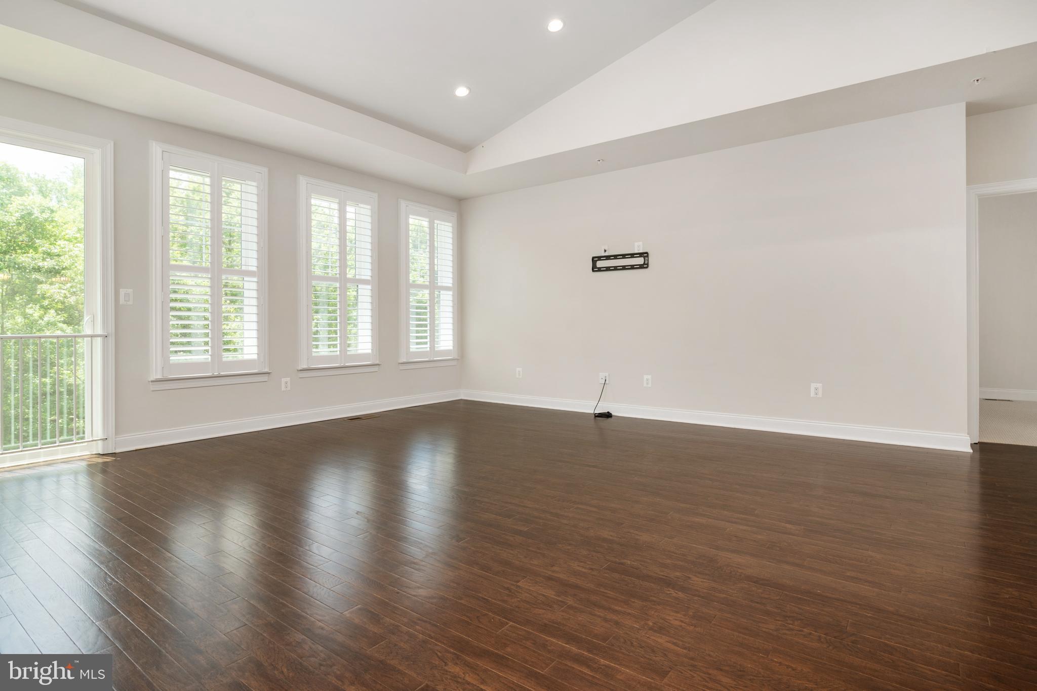 8631 St Anthony Drive Severn, MD 21144 - Photo 12 of 41 an empty room with wooden floor and windows
