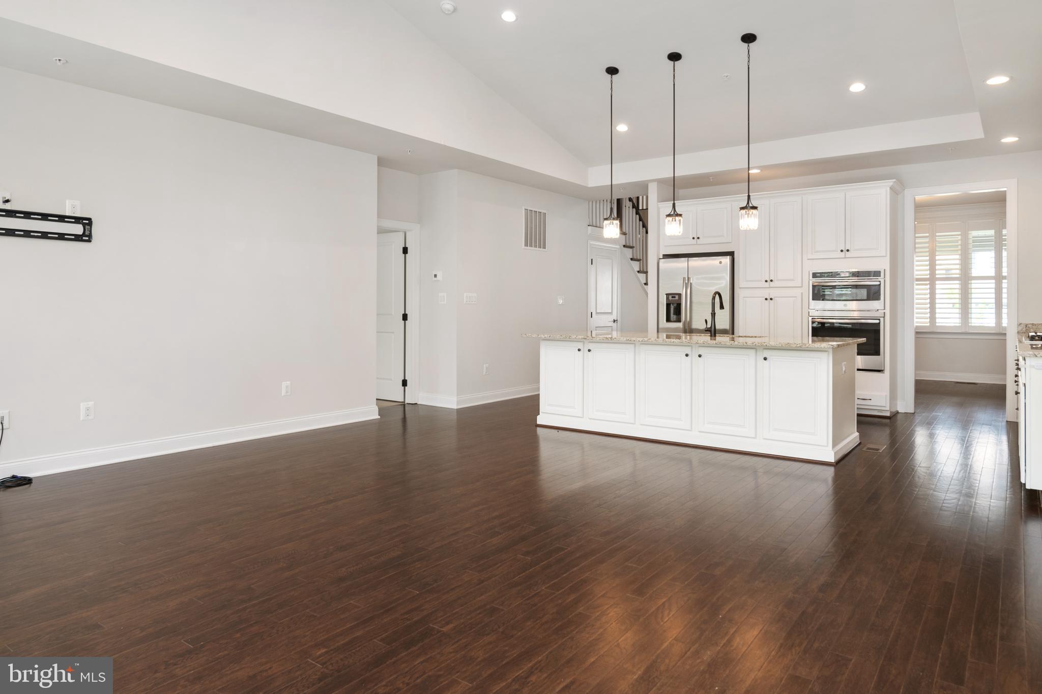 8631 St Anthony Drive Severn, MD 21144 - Photo 13 of 41 a large white kitchen with wooden floor