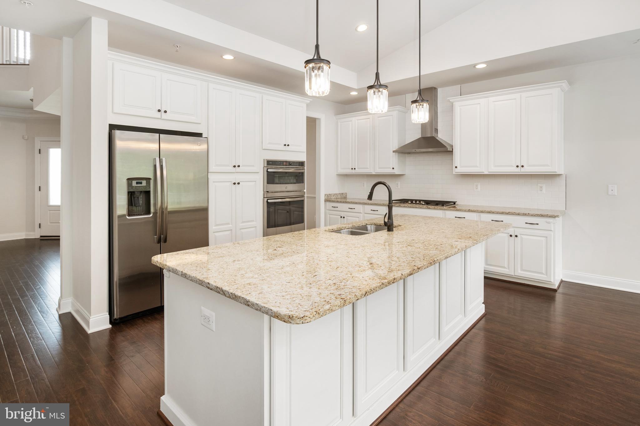 8631 St Anthony Drive Severn, MD 21144 - Photo 14 of 41 a kitchen with stainless steel appliances granite countertop a sink and a refrigerator