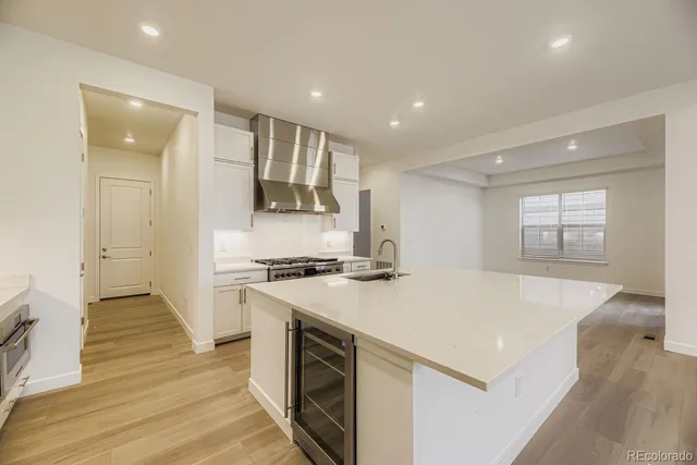 a large kitchen with stainless steel appliances granite countertop a stove and a refrigerator