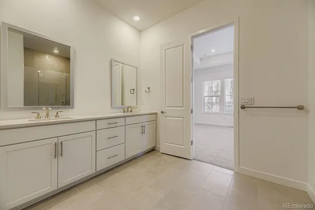 a spacious bathroom with 2 sink and a mirror