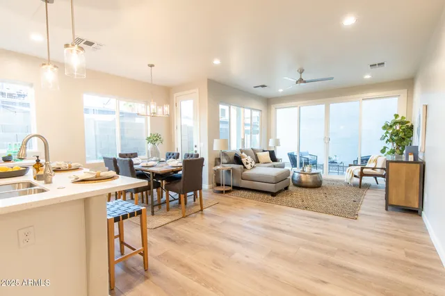 a kitchen with stainless steel appliances granite countertop a refrigerator a sink dishwasher a stove and white cabinets with wooden floor