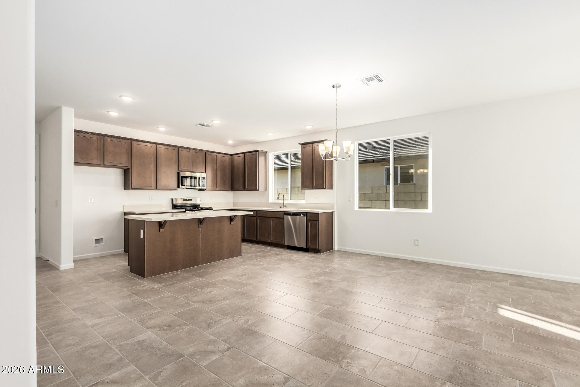 13232 West W Ranch Peoria, AZ 85383 - Photo 4 of 24 a large kitchen with a large counter top stainless steel appliances and cabinets