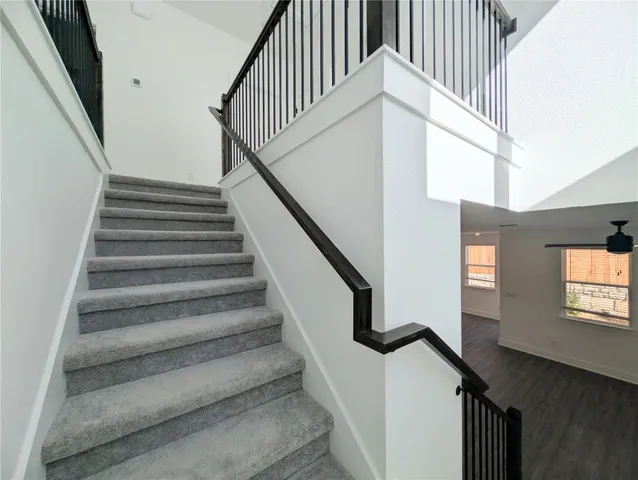a view of a white house with a small yard and wooden fence