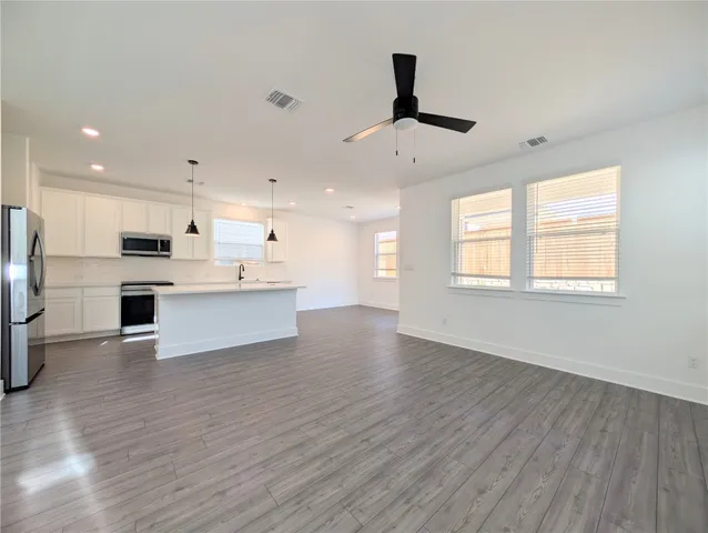 a view of kitchen with stainless steel appliances refrigerator stove microwave and cabinets