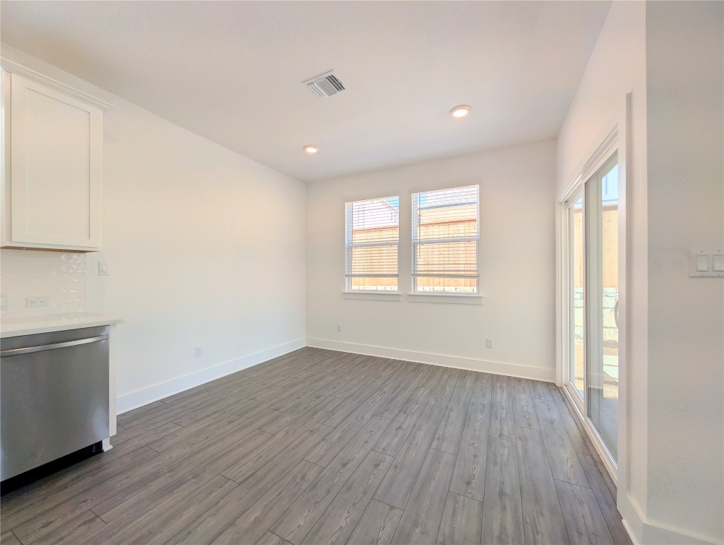 113 Sycamore Pnes Lane Kyle, TX 78640 - Photo 6 of 32 a view of an empty room with wooden floor and a window