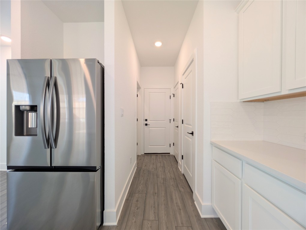 113 Sycamore Pnes Lane Kyle, TX 78640 - Photo 9 of 32 a view of a kitchen with a refrigerator and cabinets