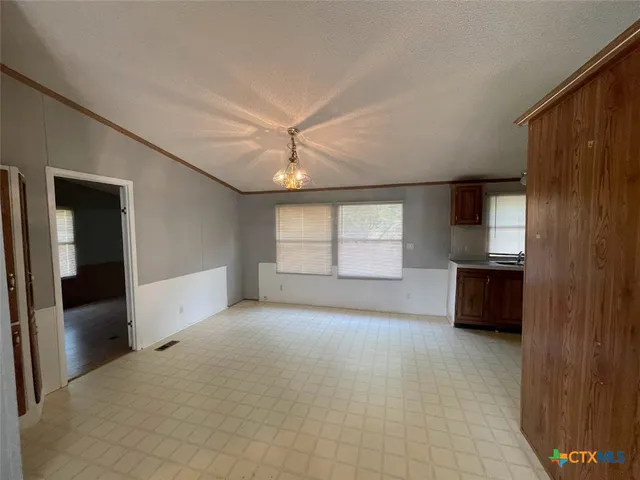 en empty room with windows and ceiling fan