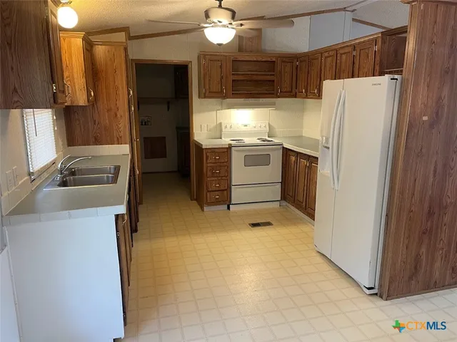 a kitchen with a refrigerator and a stove top oven