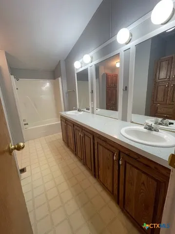 a bathroom with a sink double vanity granite and a large mirror