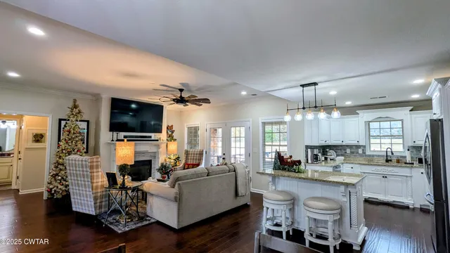 a living room with furniture kitchen view and a large window