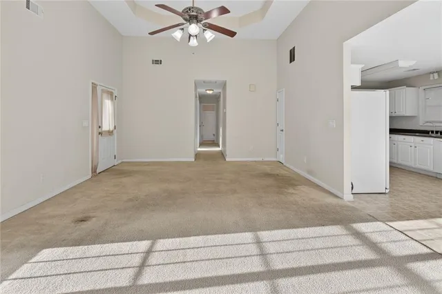 a view of a livingroom with a chandelier fan and refrigerator