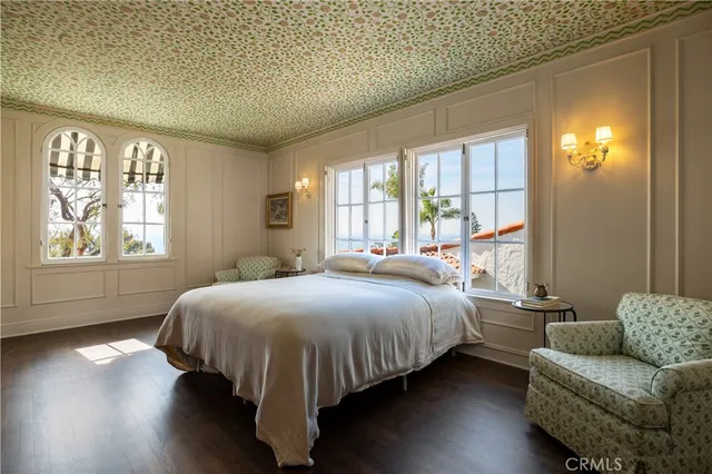 a bedroom with a bed and a couch with wooden floor