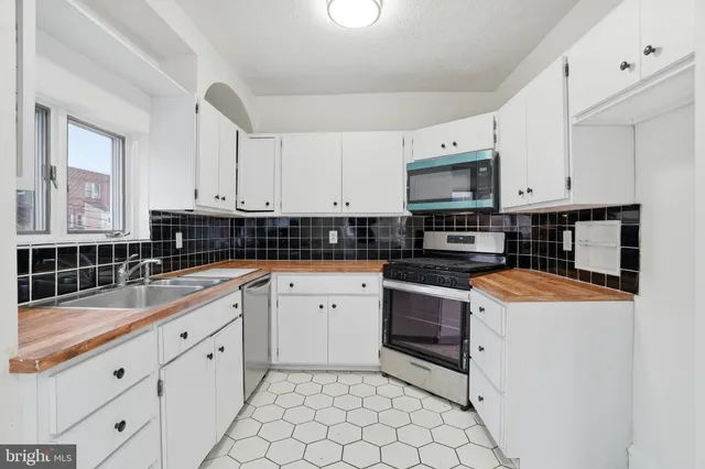 a kitchen with granite countertop white cabinets and white appliances