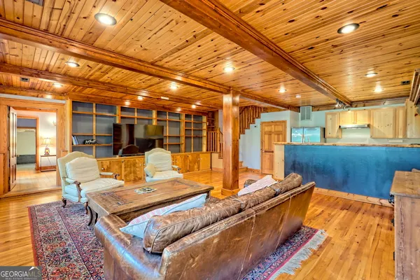 a kitchen with stainless steel appliances granite countertop a refrigerator a sink dishwasher a stove with wooden cabinets and wooden floor