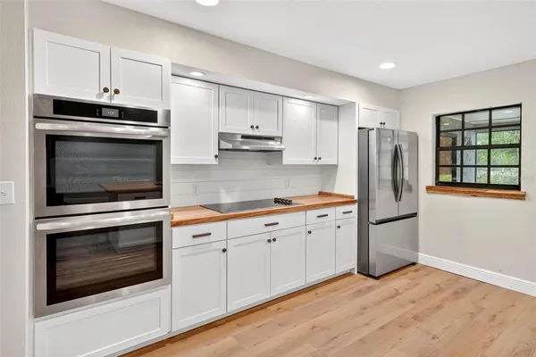 a view of a kitchen with wooden floor and electronic appliances