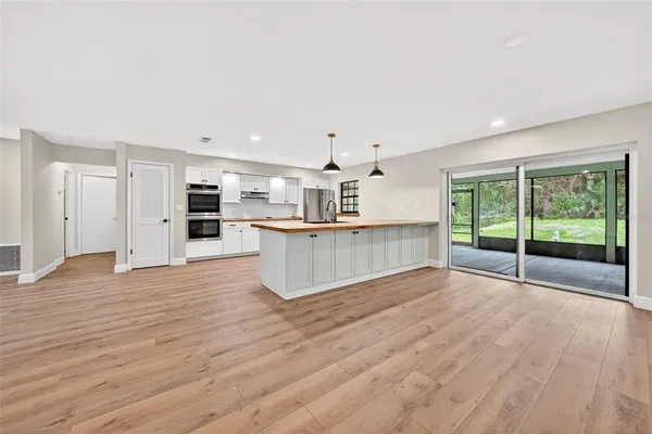 a view of a kitchen with stainless steel appliances wooden floor and staircase