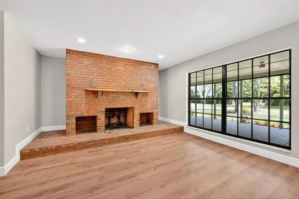 a open kitchen with kitchen island a stove a refrigerator cabinets and wooden floor