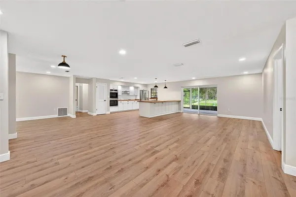 a view of empty room with wooden floor and a fireplace