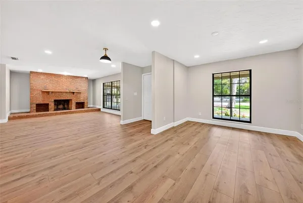 a view of a big room with wooden floor and a ceiling fan