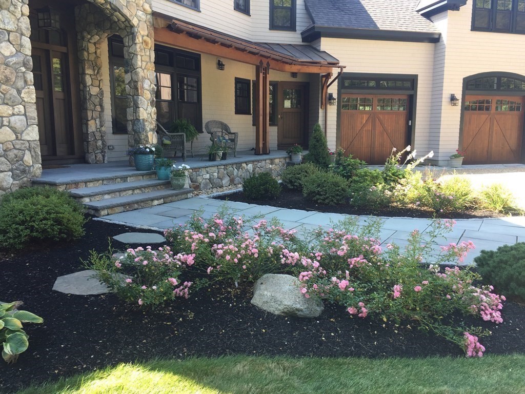 a front view of a house with a yard and flowers