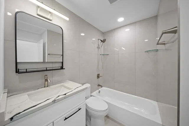 a bathroom with a toilet a sink a mirror and a bathtub