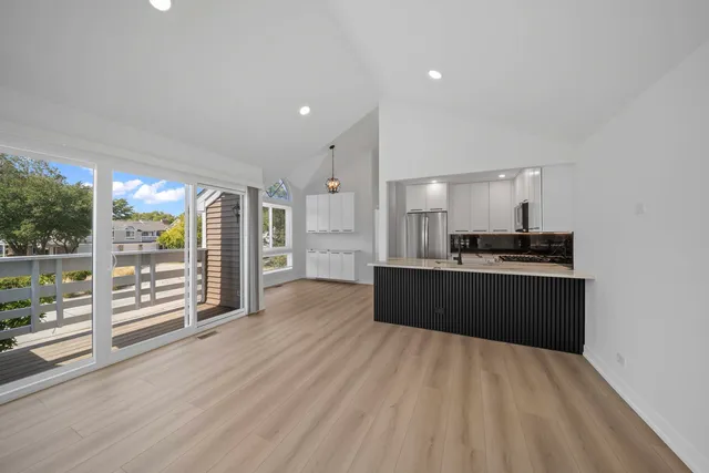 a kitchen with stainless steel appliances kitchen island wooden cabinets and wooden floor