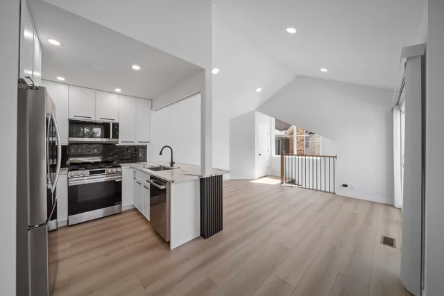 a kitchen with stainless steel appliances kitchen island granite countertop a stove a sink and a refrigerator