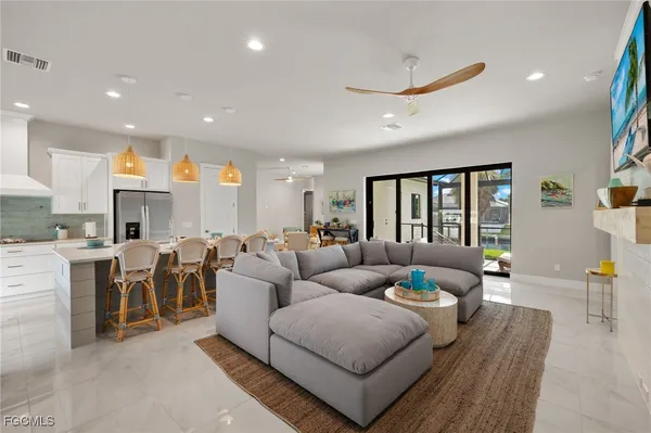 a living room with furniture kitchen view and a large window