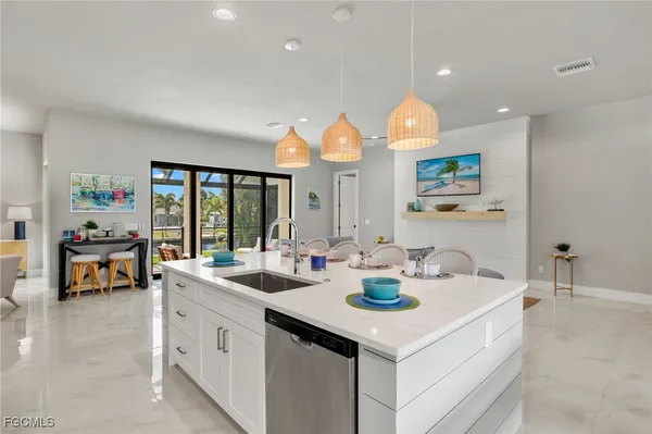 a kitchen with a sink cabinets and living room view