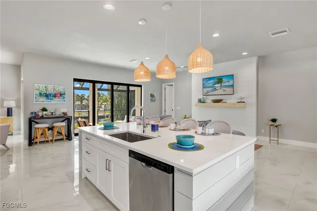 a kitchen with a sink cabinets and living room view