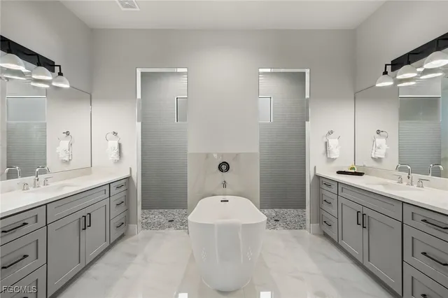 a spacious bathroom with a double vanity sink a large mirror and a bathtub