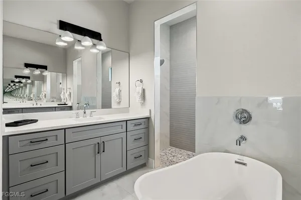 a bathroom with a tub sink and mirror