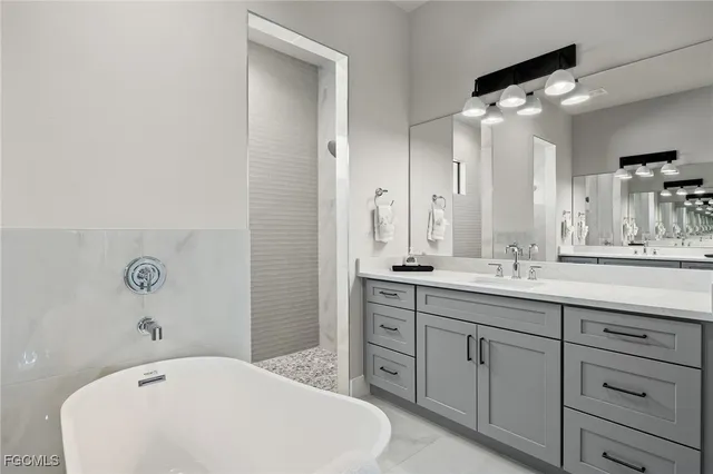 a bathroom with a tub sink and mirror