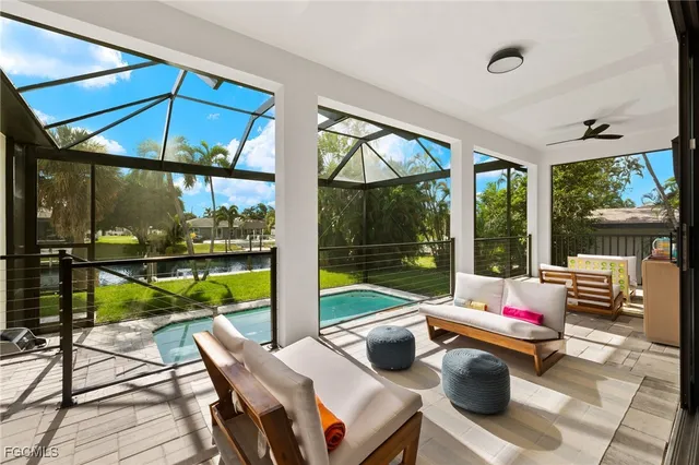 a living room with patio furniture and a floor to ceiling window
