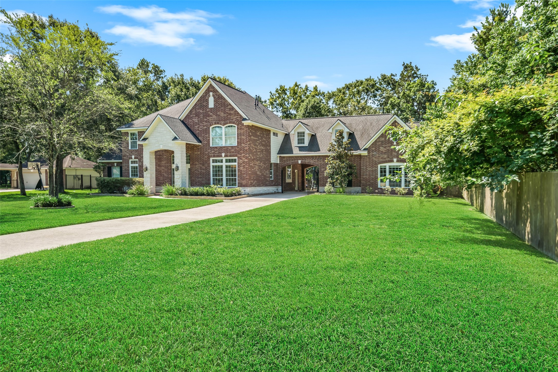 2302 Legends Shore Drive Spring, TX 77386 - Photo 4 of 48 Elegant brick and stone exterior surrounded by mature landscaping.